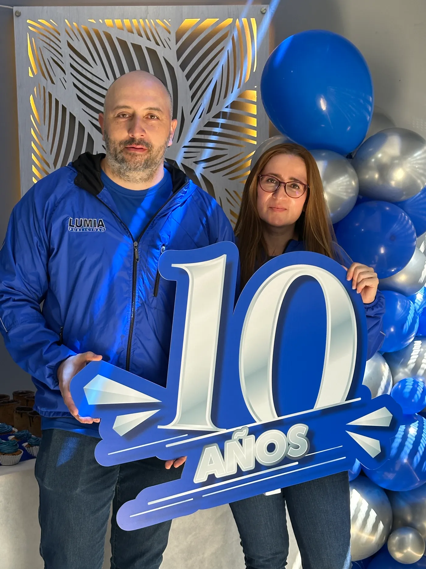 Equipo de Lumia Publicidad con el letrero de 10 años